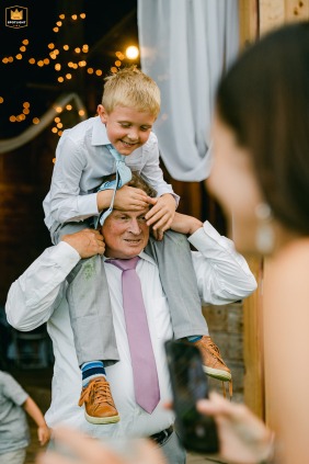 At The Barn at White Rocks in Wallingford, Vermont, a spontaneous moment of pure joy unfolds as a grandson rides on his grandfather's shoulders.